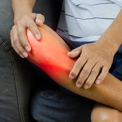 a person is holding their knee in pain from personal Injury