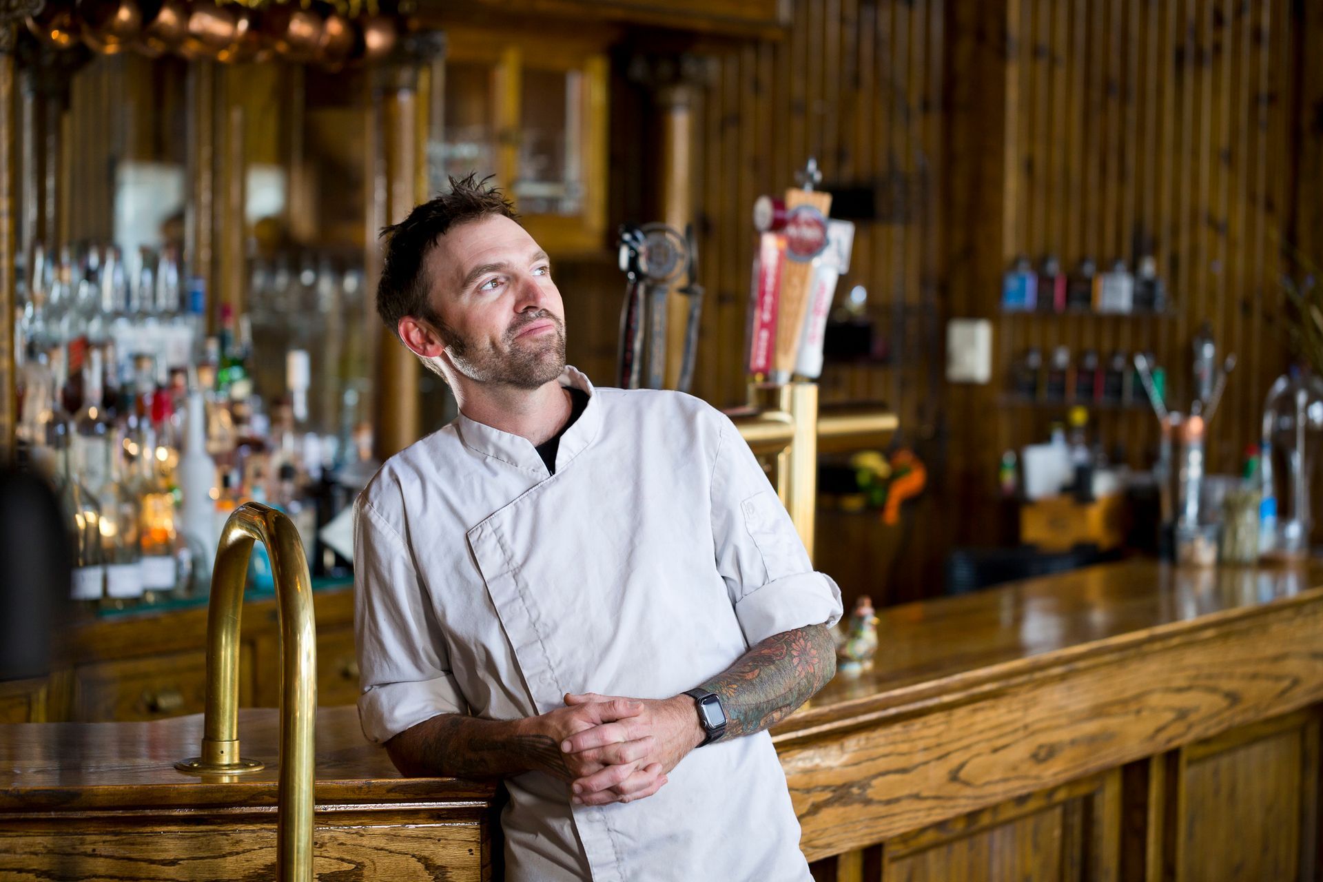A man is standing in a room with pipes and looking at a tablet.