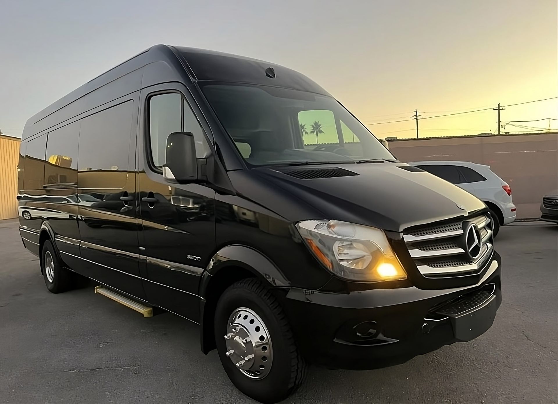 A black mercedes van is parked in a parking lot.