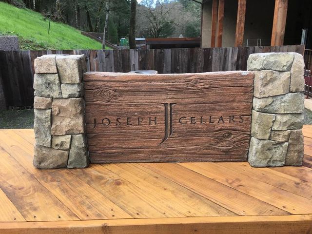 A wooden sign that says joseph cellars is sitting on a wooden table.
