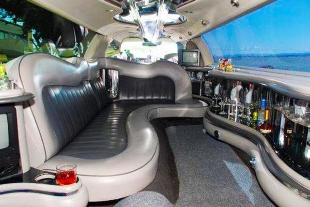 The inside of a limousine with a couch and a bar