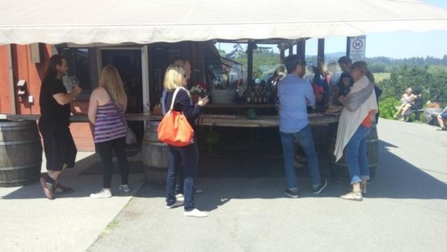 A group of people standing around a table under a tent