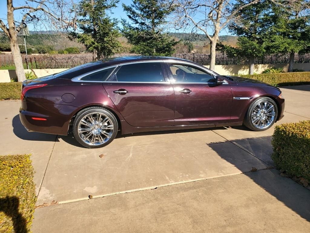 A purple jaguar x type is parked in a driveway.