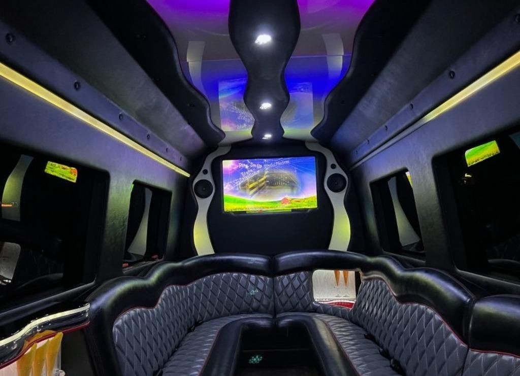 The inside of a limousine with a tv on the ceiling