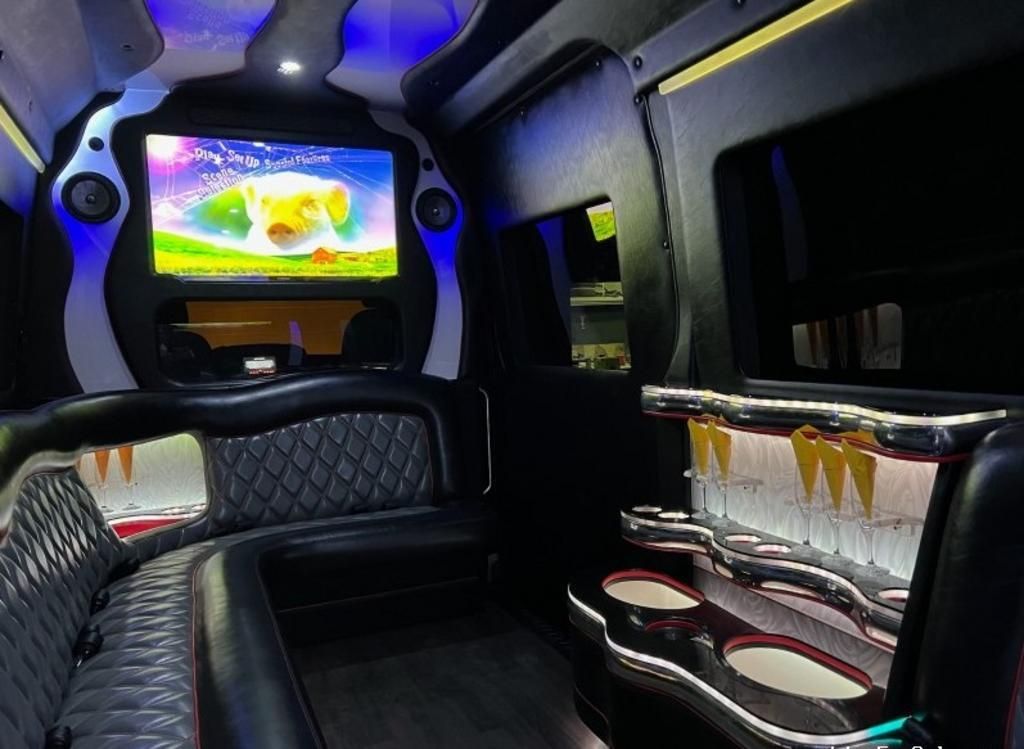 The inside of a limousine with a flat screen tv
