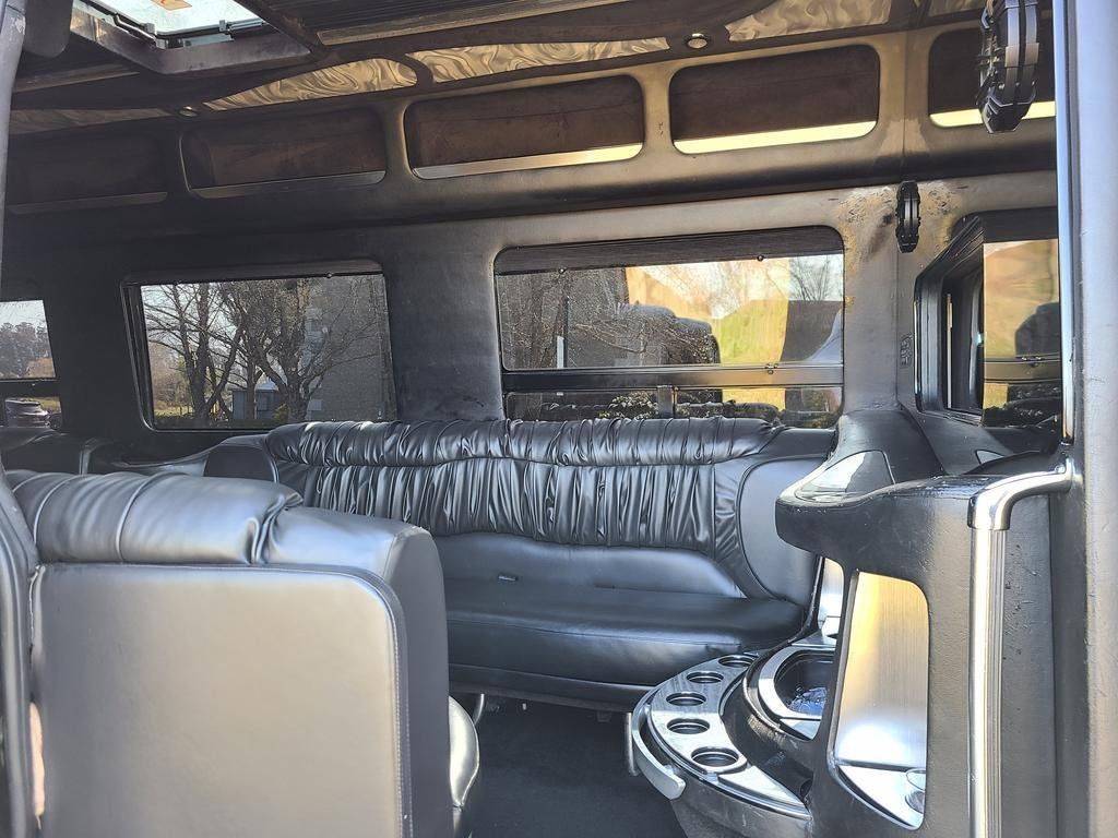 The inside of a limousine with a couch and a bar.