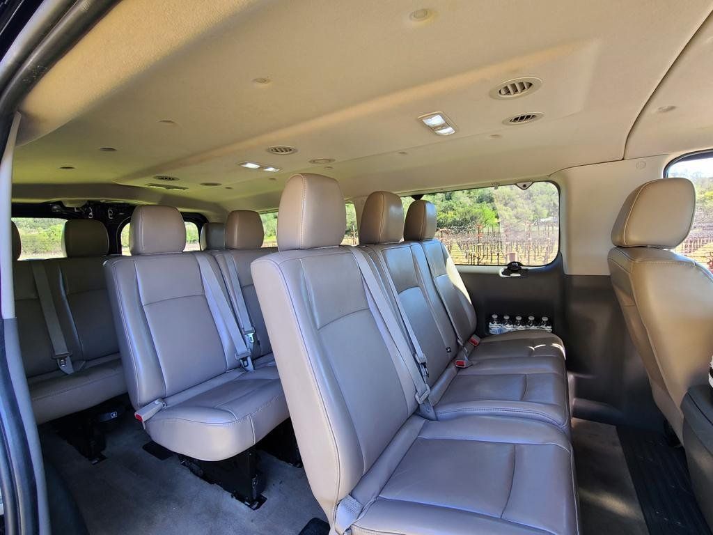 The inside of a van with a lot of seats and a ceiling.
