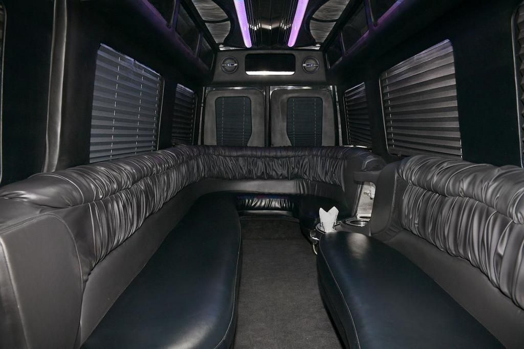 The inside of a limousine with a long couch and a table.