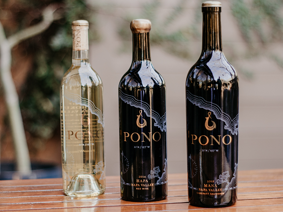 Three bottles of pono wine are sitting on a wooden table.