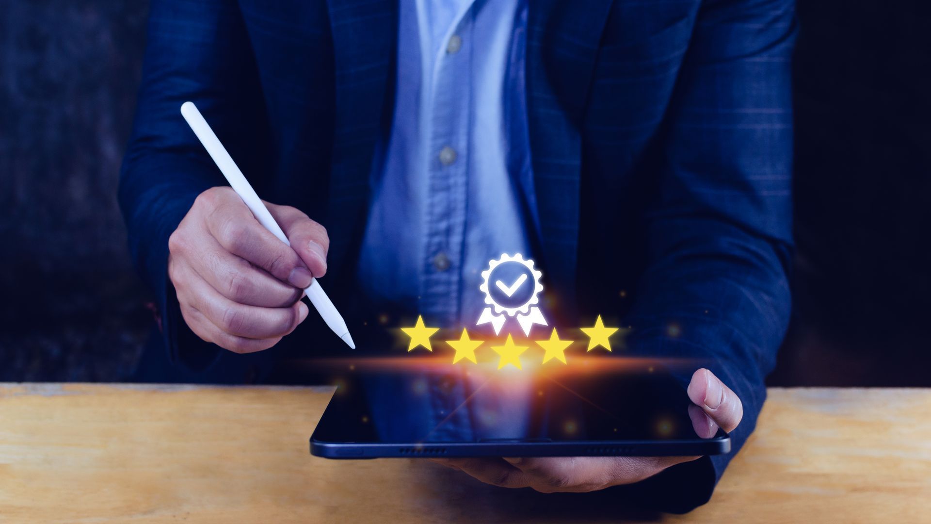 A man is holding a tablet and writing on it with a pen.