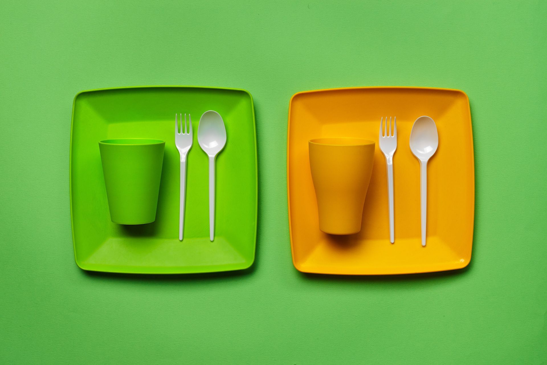 green and orange picture of two plates with a cup fork and spoon