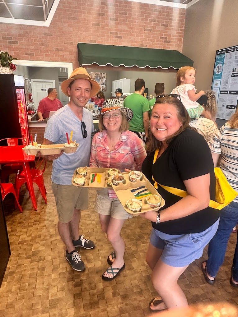 A group of people are standing in a restaurant holding trays of food.
