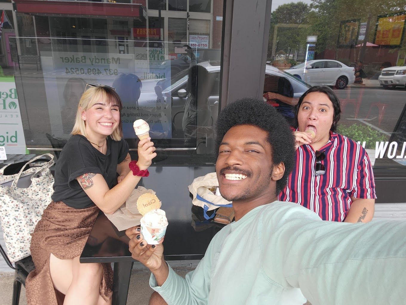 A group of people are sitting at a table eating ice cream.