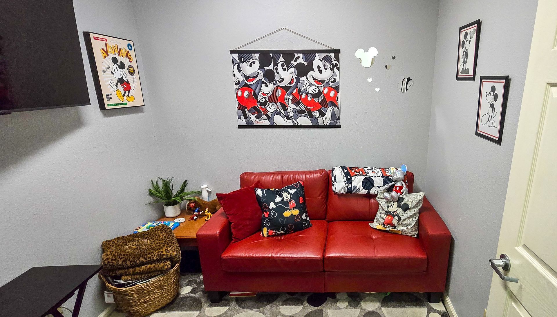 A therapy room with a red couch and a Disney motif