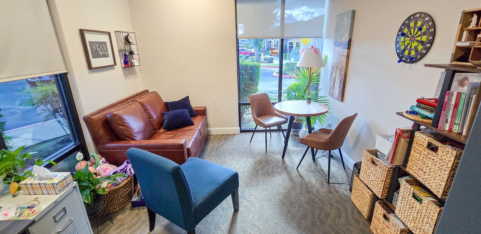 A comfortable therapy room with couches, tables and a bright window
