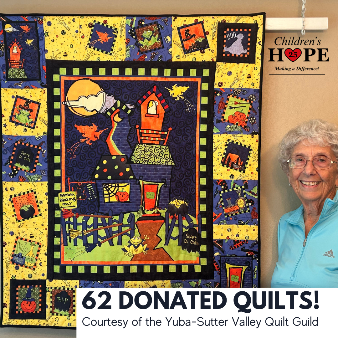 Aquilt guild member standing beside a Halloween themed uil.