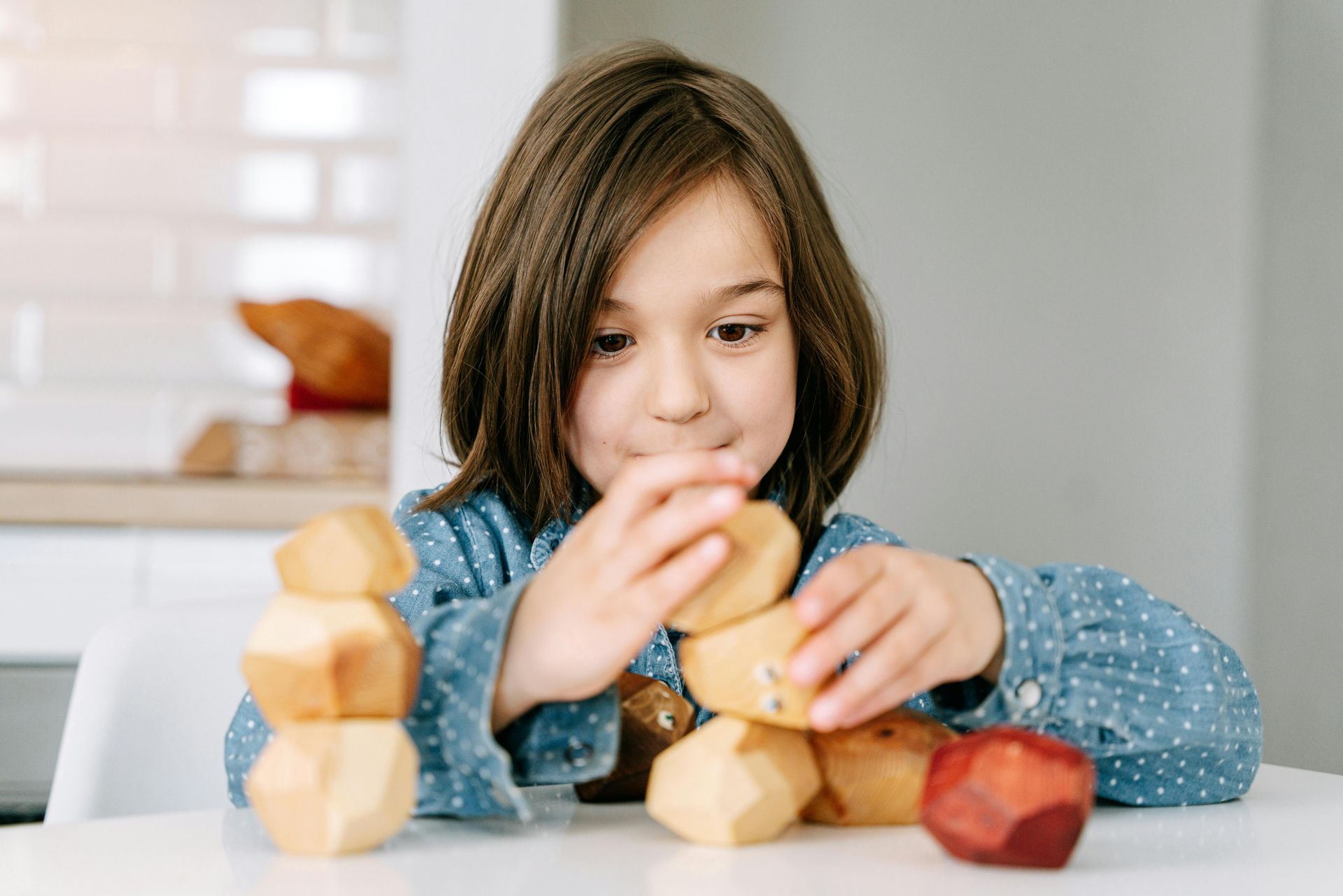 A little girl is sitting at a table eating apples.