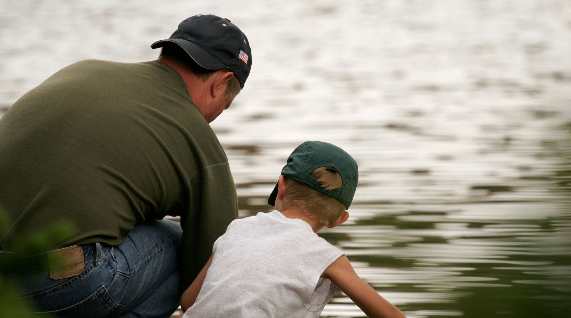 A man and a boy are looking at the water