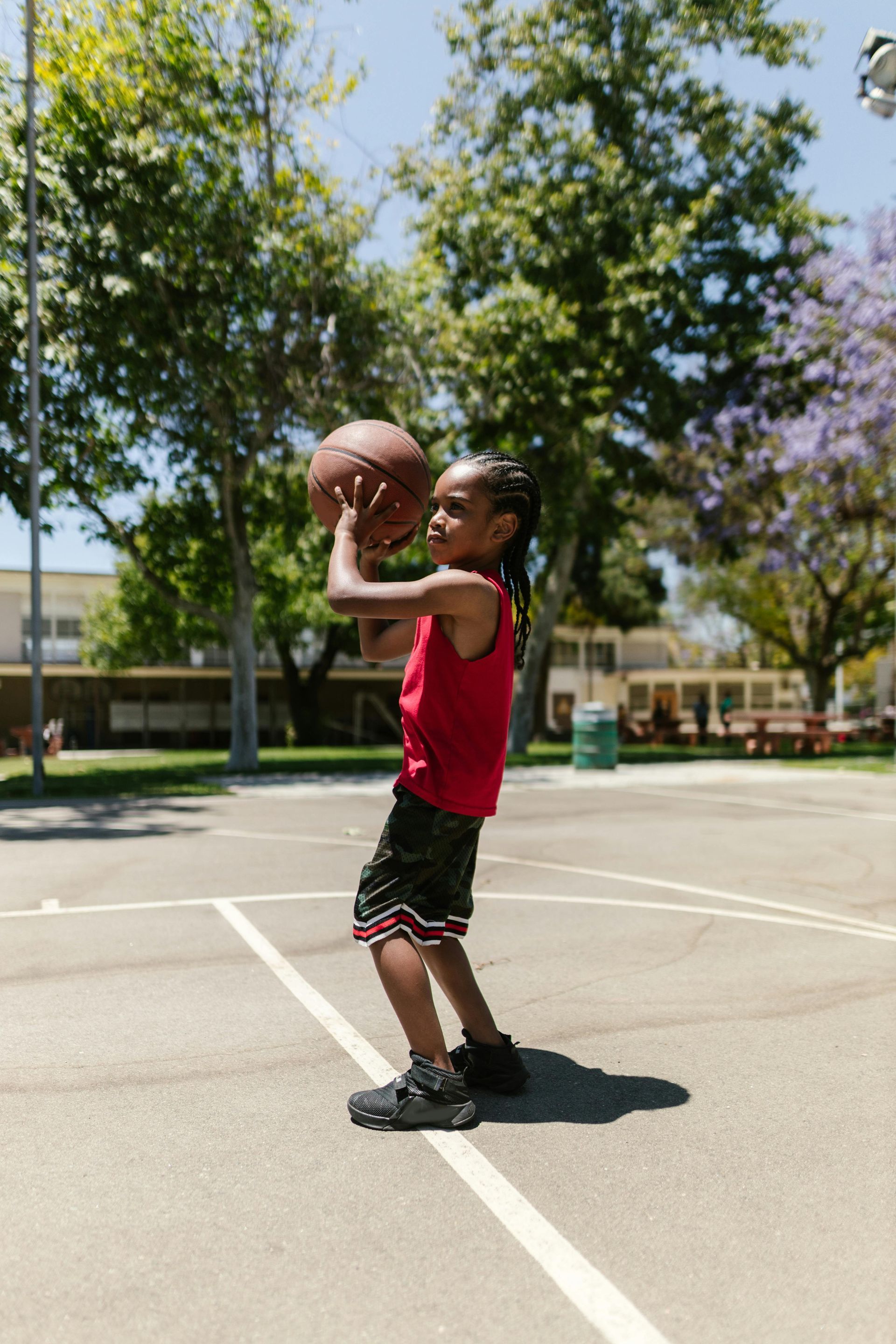 A young boy is playing basketball on a court.