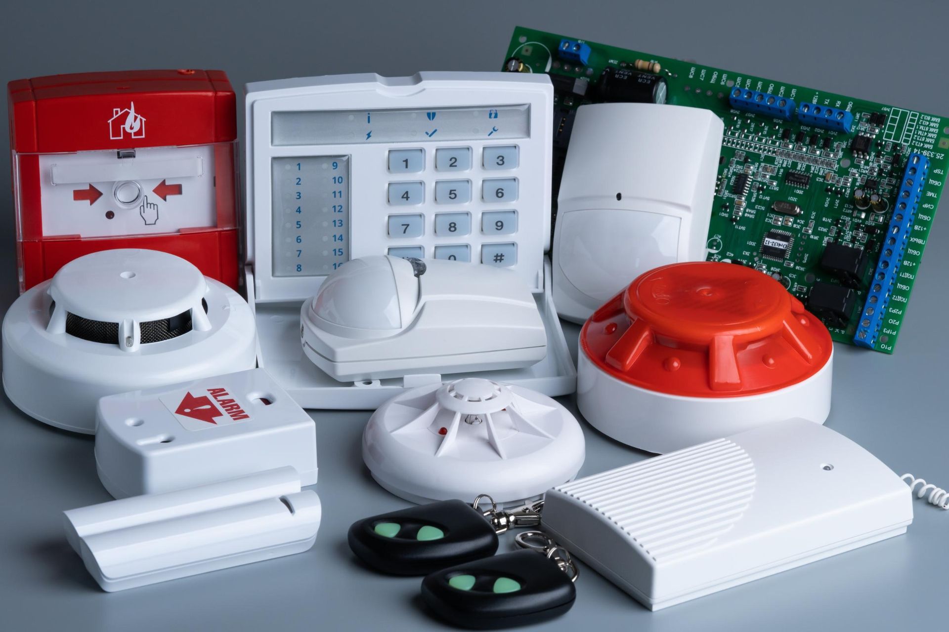 Security system components: keypad, sensors, smoke detectors, pull station, and circuit board.