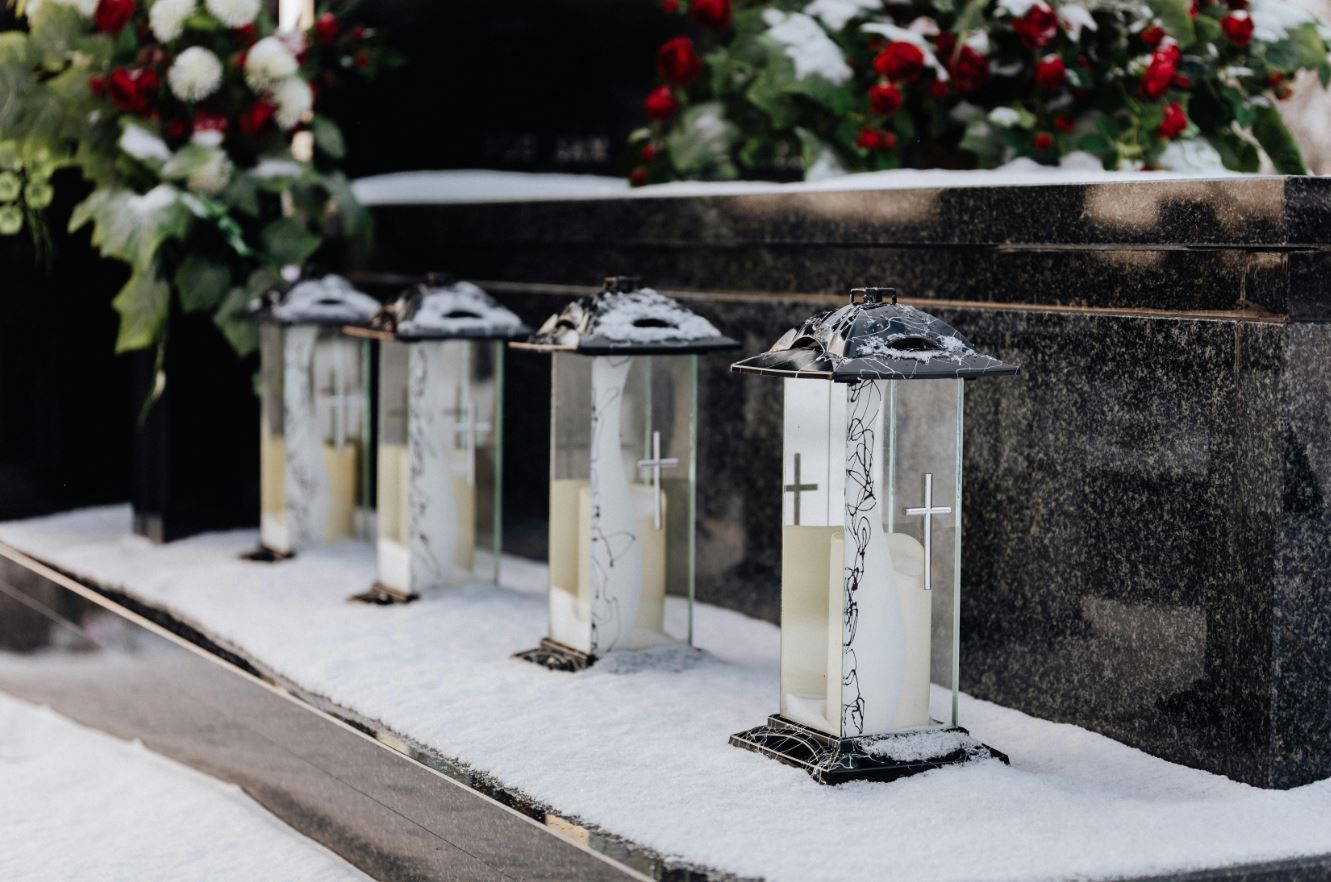 funeral lanterns with candles placed at a snowy graveside memorial setting in laredo, tx