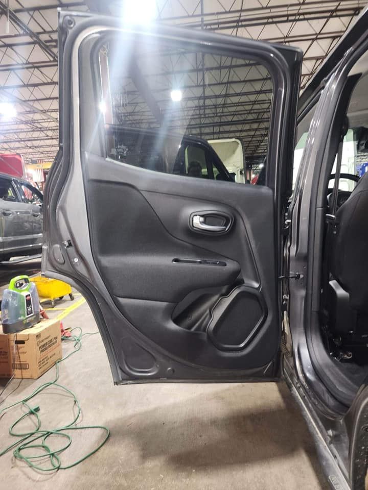 Open gray car door, interior view, showing door panel with handle, speaker, and window.