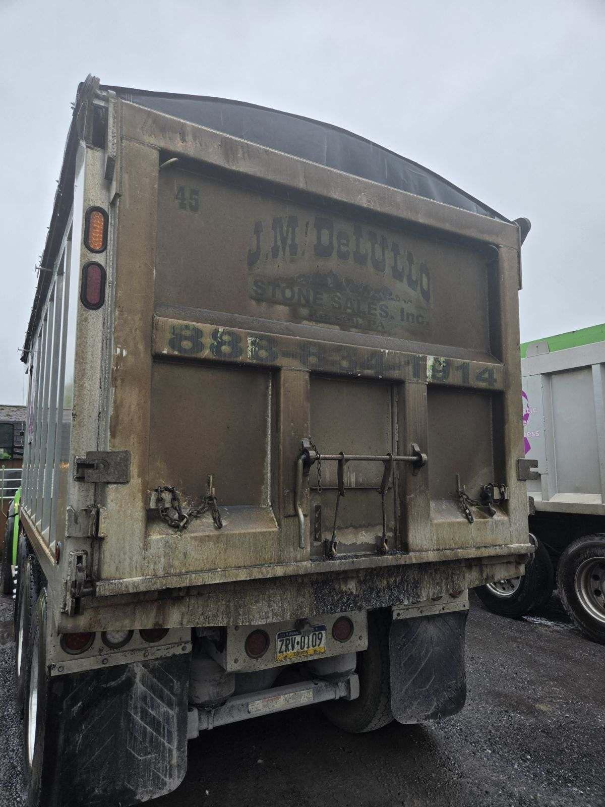 Rear view of a dump truck with the company name 