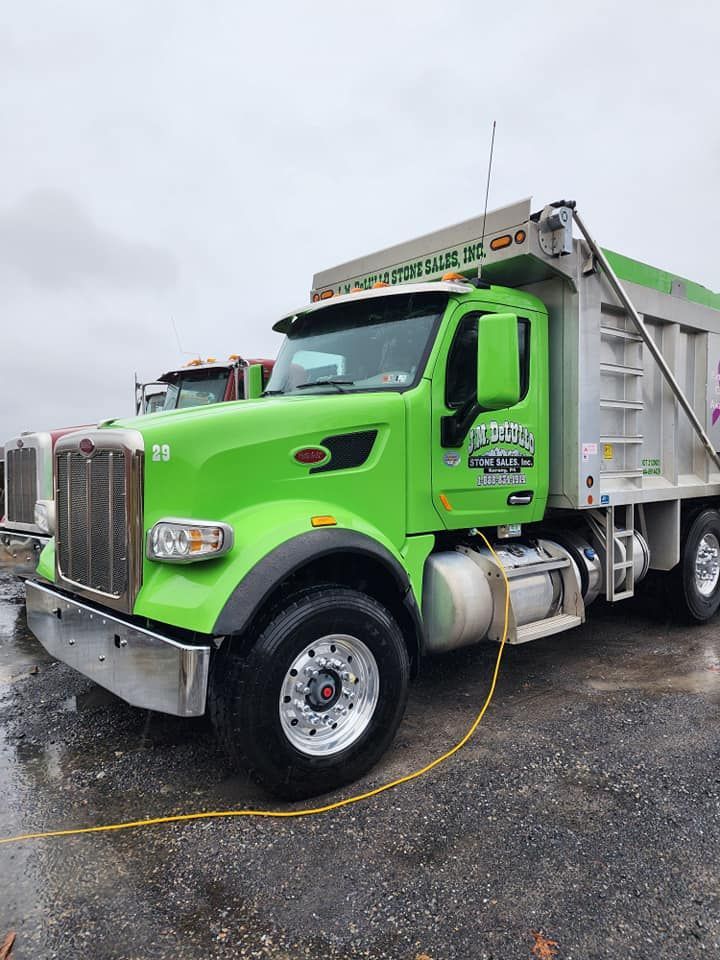 Green dump truck parked outside.