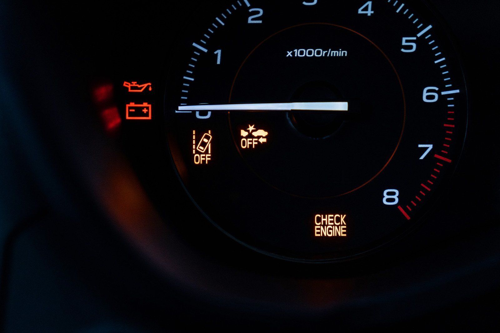 Car dashboard with warning lights illuminated: oil, battery, traction control, and check engine.