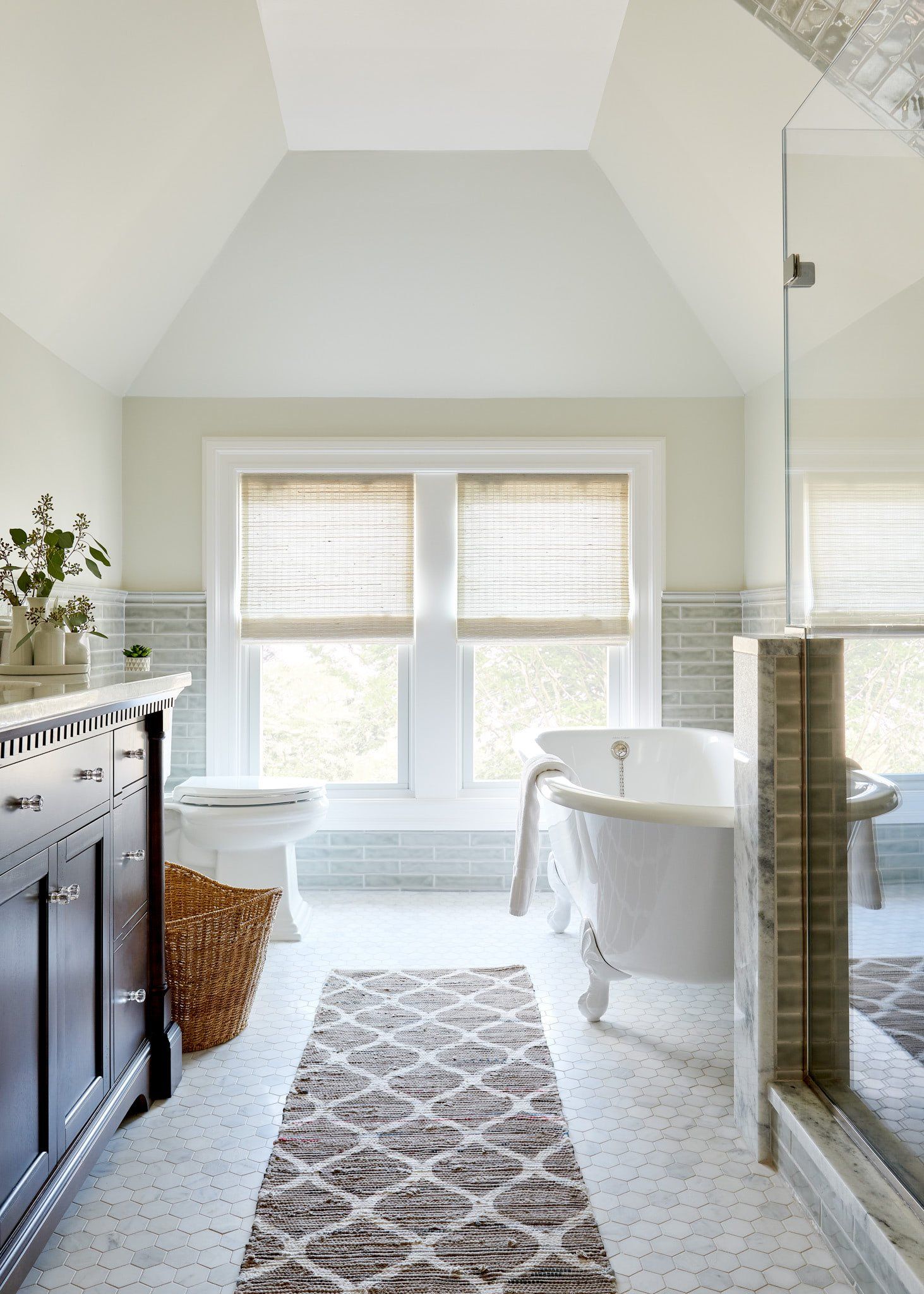 A bathroom with a tub , toilet , and mirror