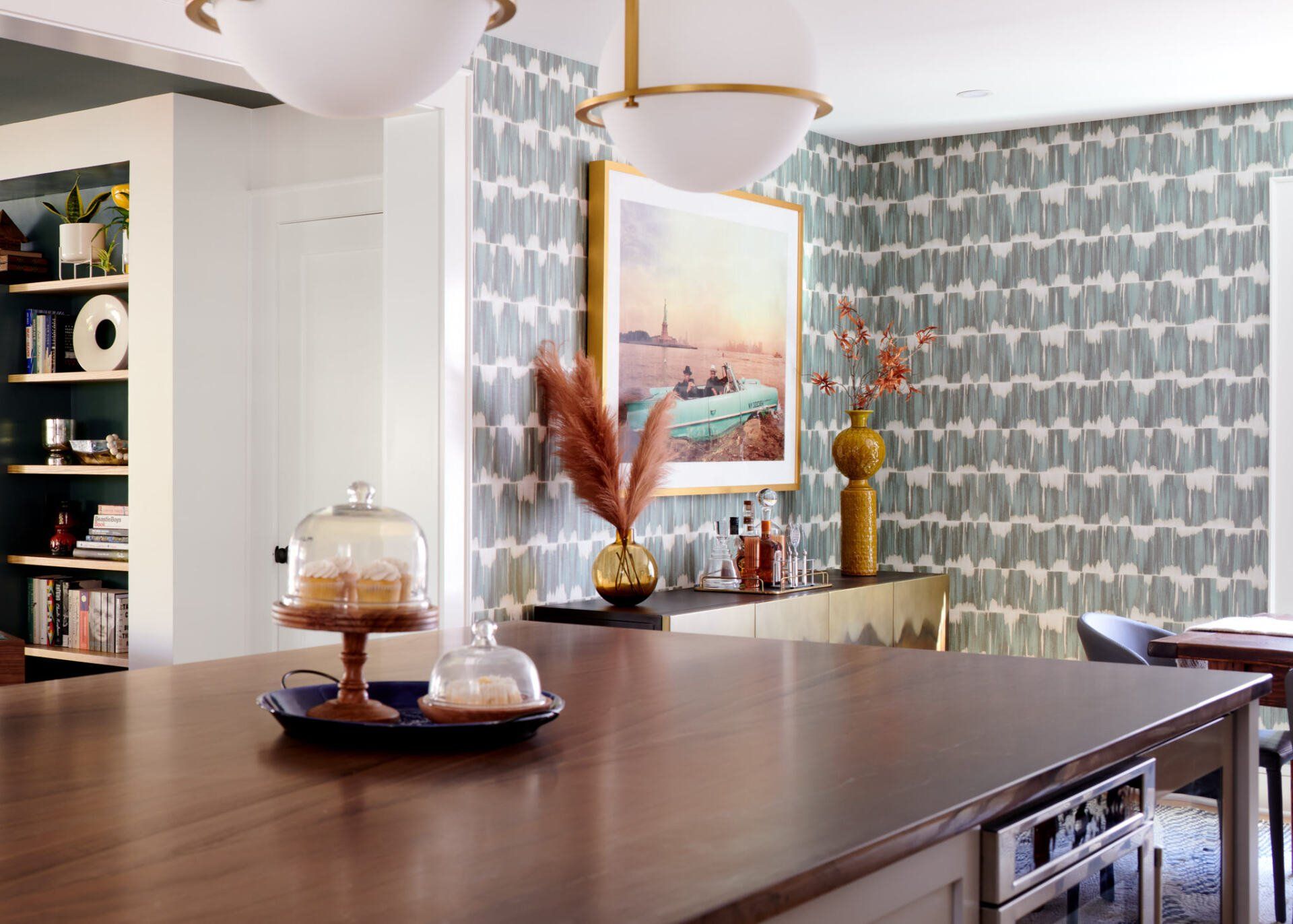 A kitchen with a large island and a painting on the wall.