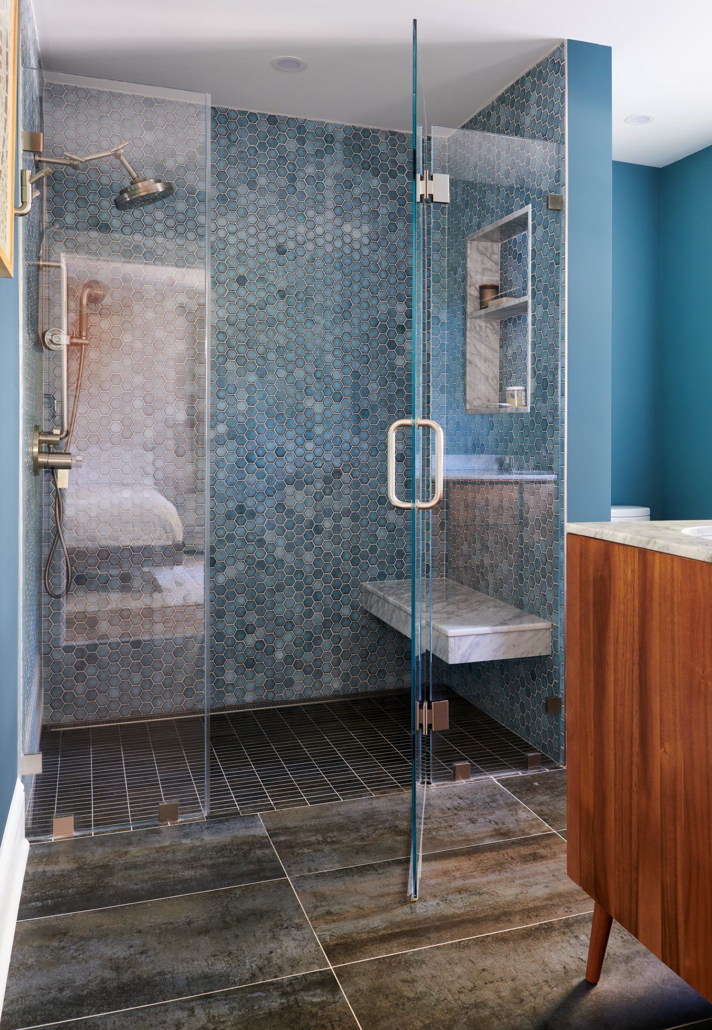 A bathroom with a walk in shower and a sink