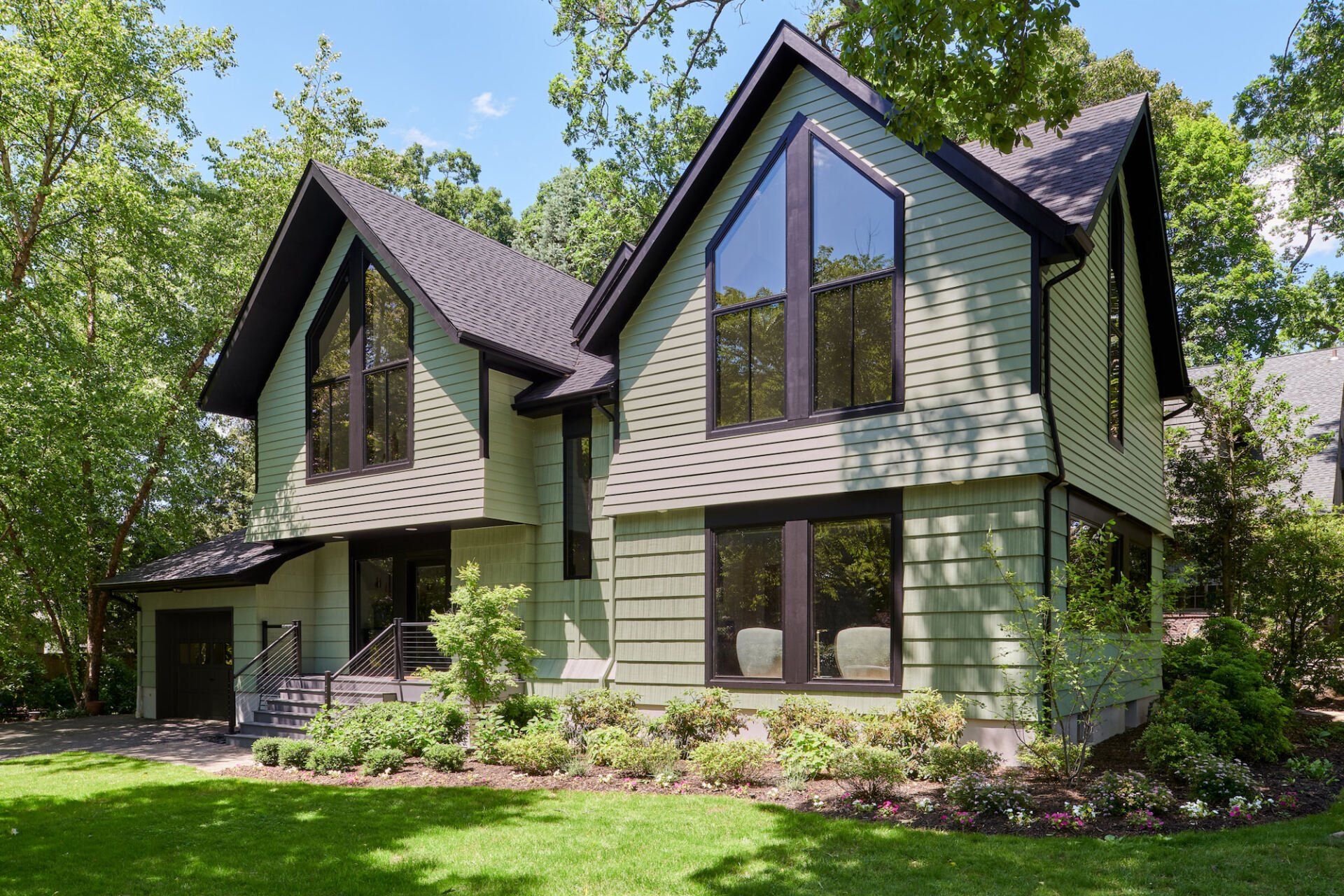 A large house with a lot of windows is surrounded by trees.
