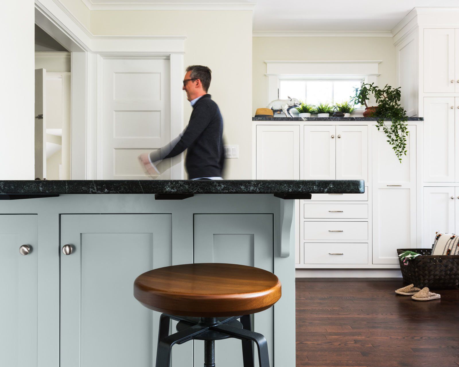 A man is standing behind a counter in a kitchen.