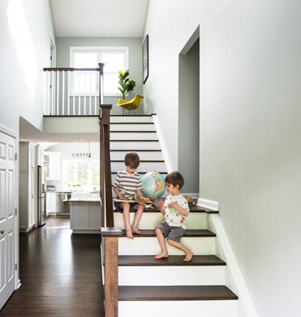 Two children are sitting on a set of stairs looking at a globe