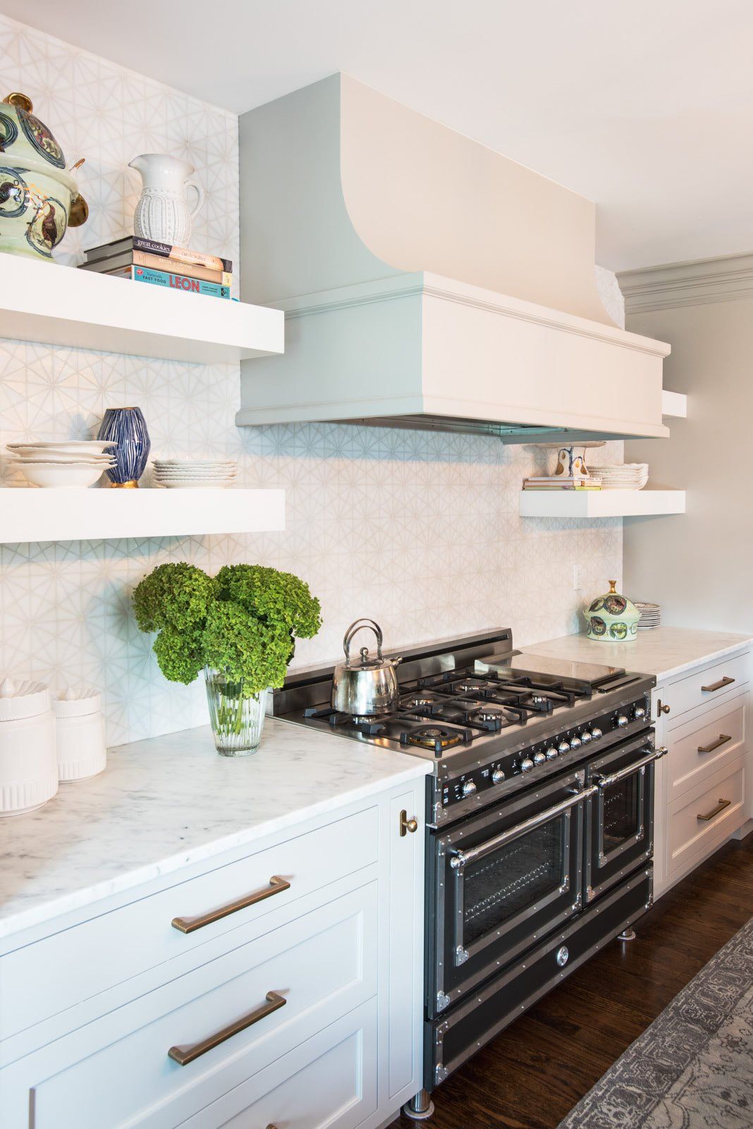 A kitchen with a black stove top oven and white cabinets.