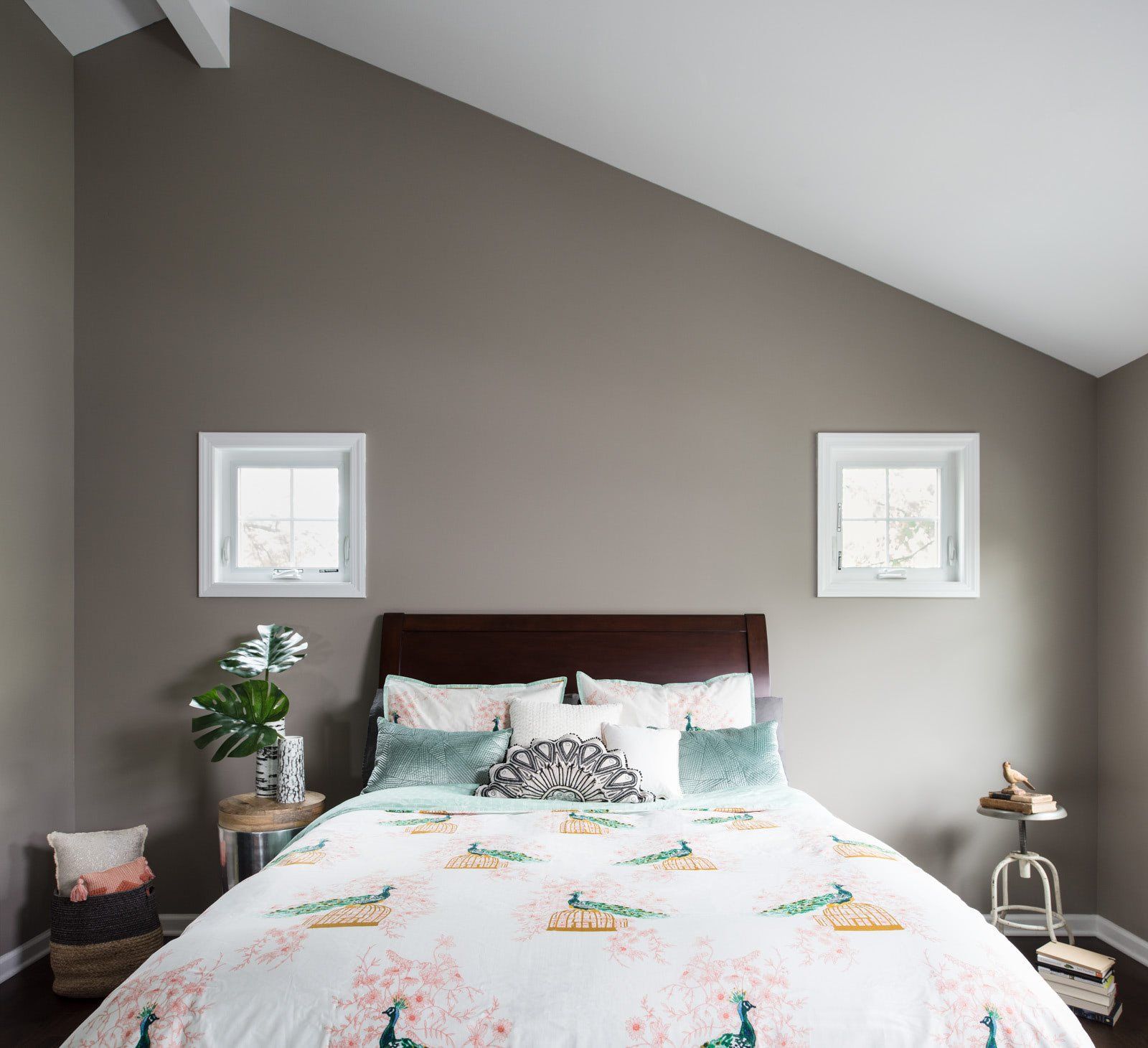 A bedroom with a vaulted ceiling and a bed with a floral comforter