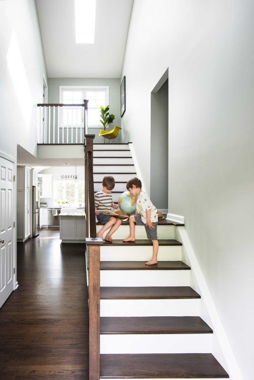 Two children are playing on the stairs of a house.