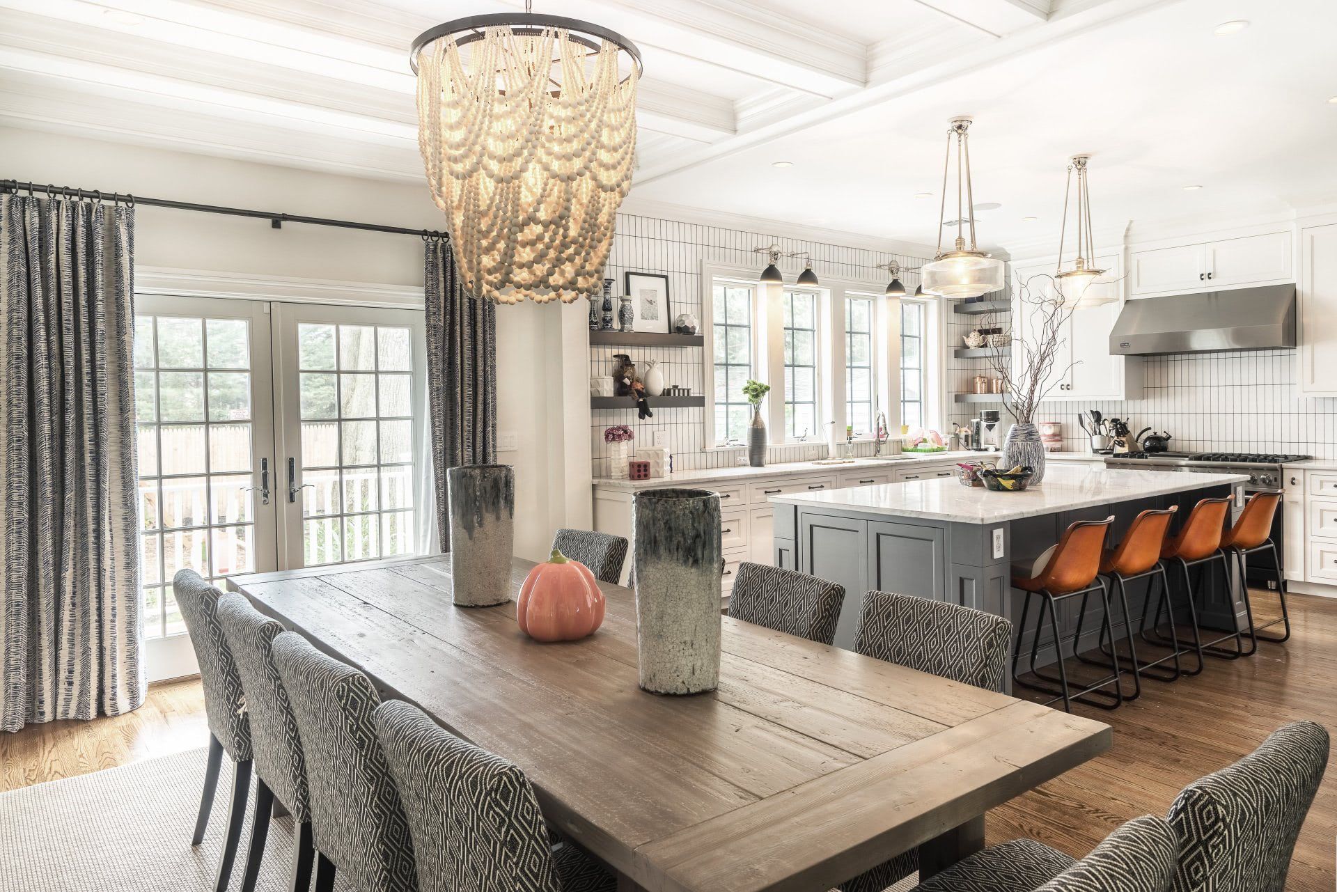 A dining room table and chairs in a kitchen with a chandelier hanging from the ceiling.