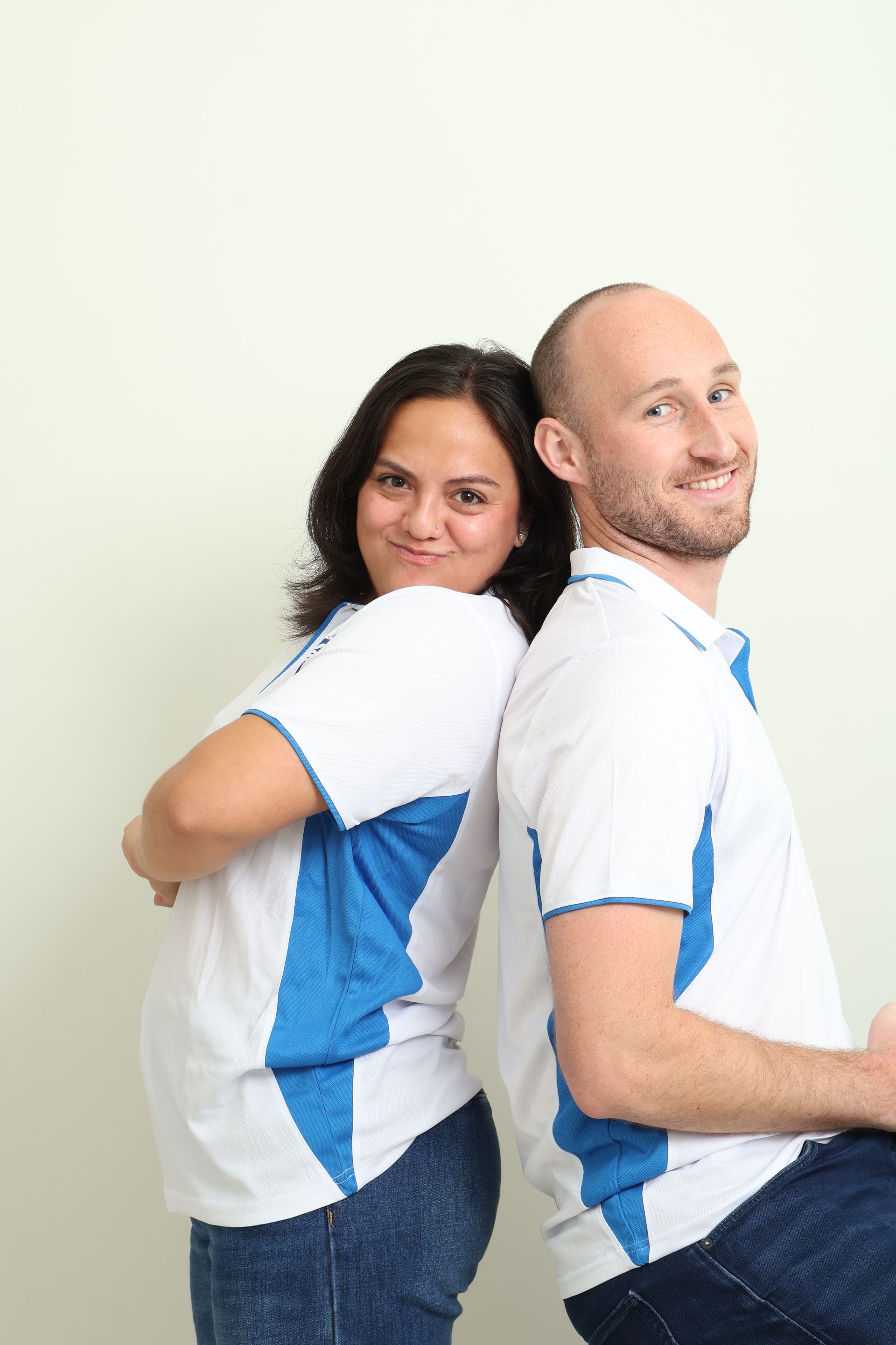 Two Tío Tours guides in white and blue uniforms, standing back-to-back, ready to lead a Madrid free walking tour.