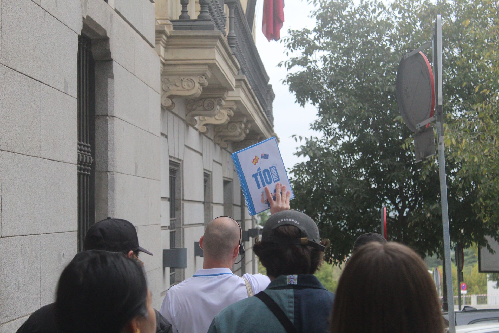 Enthusiastic Tío Tours guide walking with a group, highlighting the vibrant experience of a Madrid Free Walking Tour.