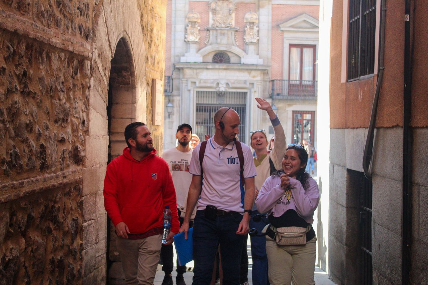 Visitors explore a charming Madrid alleyway with textured stone walls during an insightful Madrid Free Walking Tour.