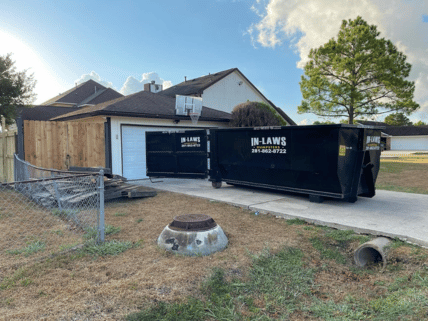 A dumpster is parked in front of a house.