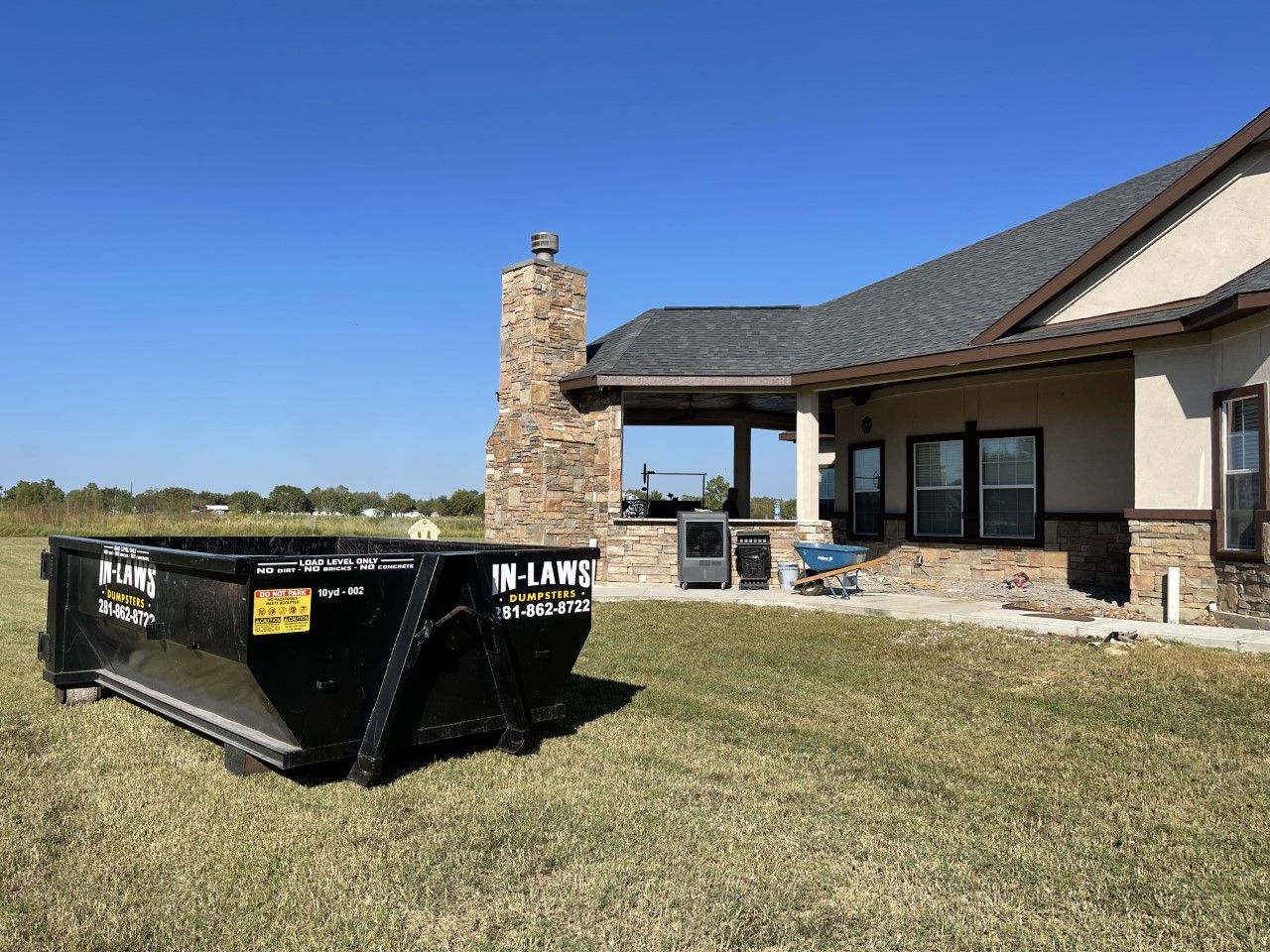 A large dumpster is parked in front of a house.