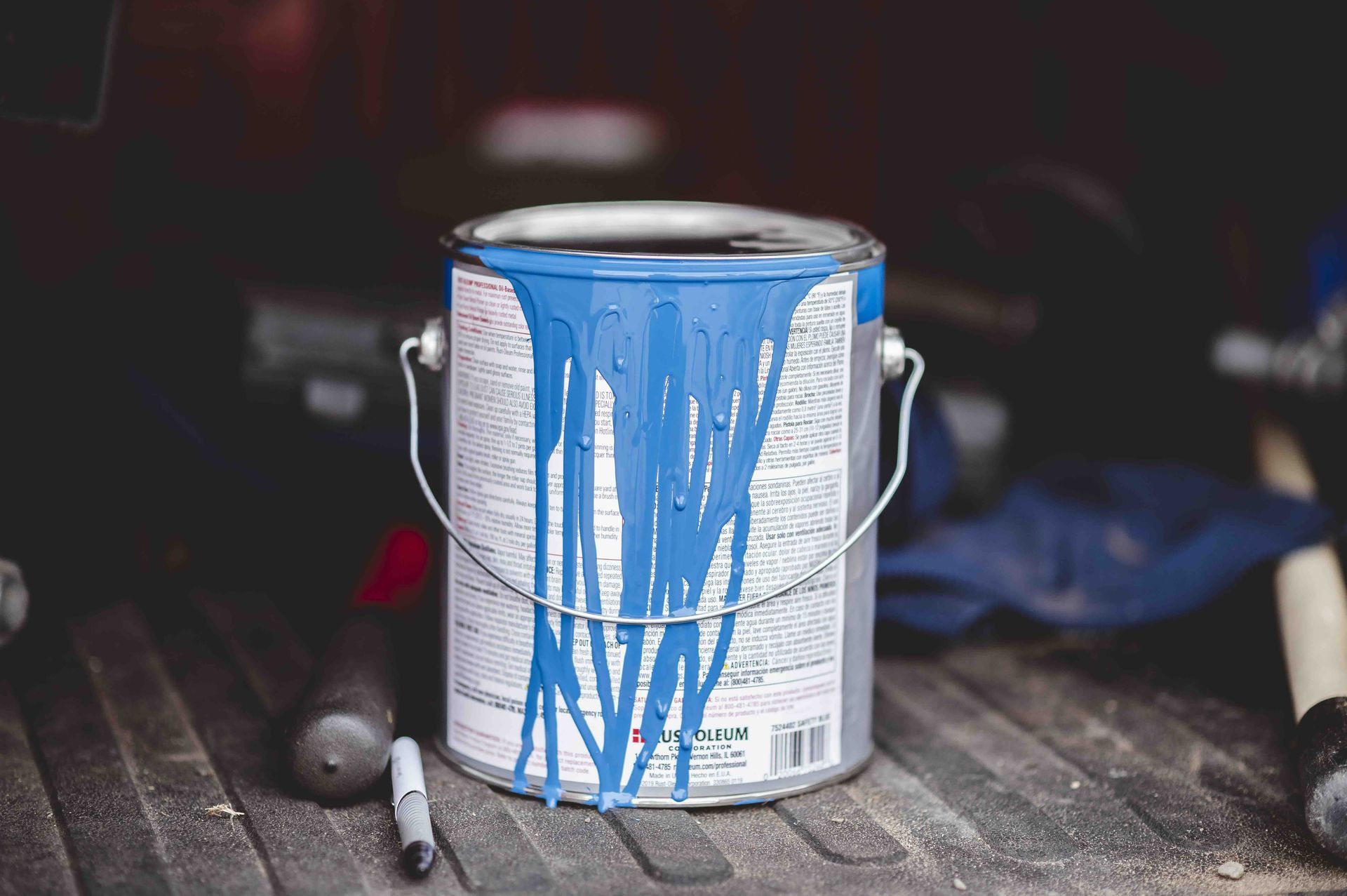 A photo of a paint can with blue paint drips, illustrating how to dispose of paint safely.
