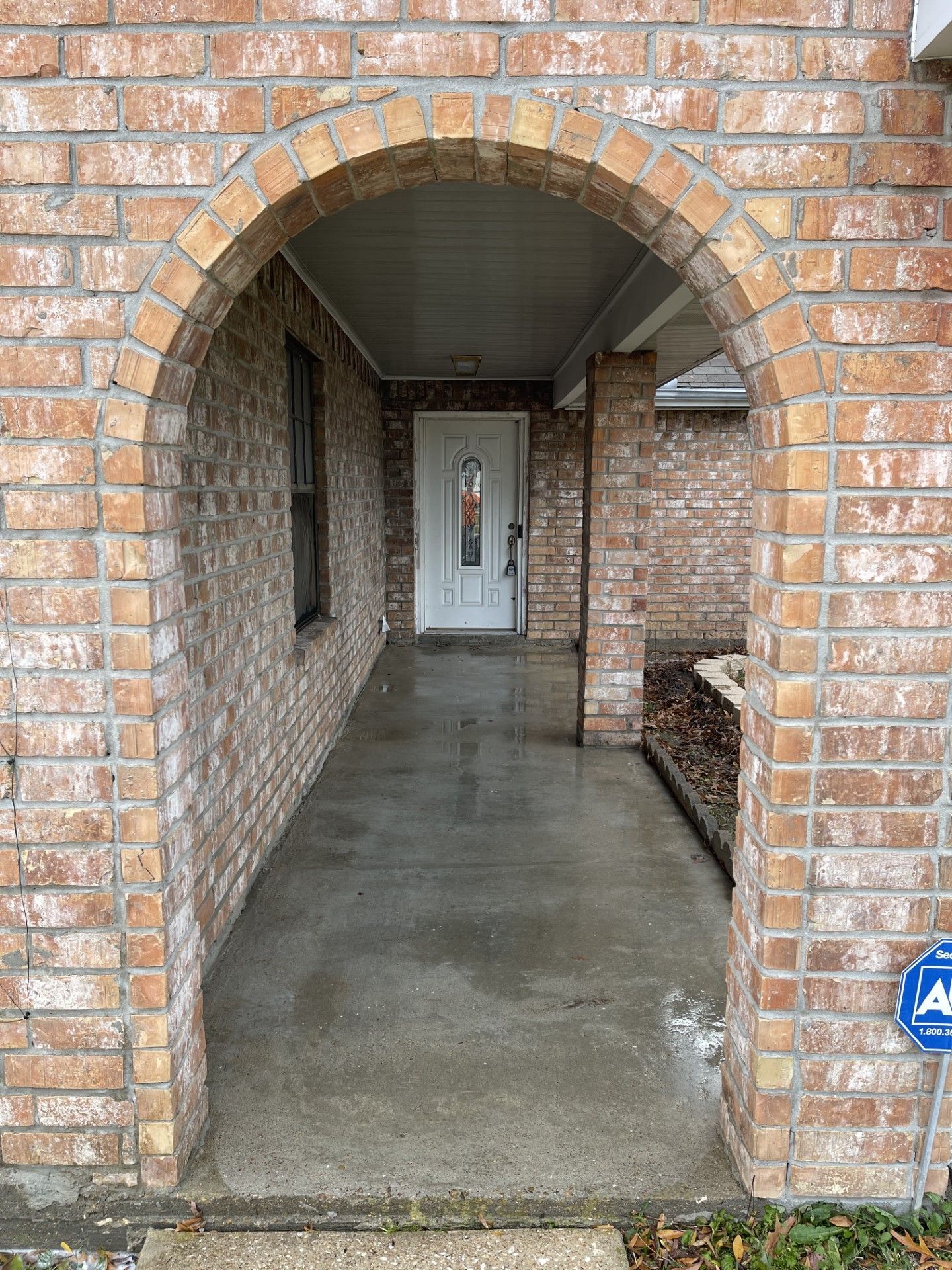 A brick walkway leading to the front door of a house.