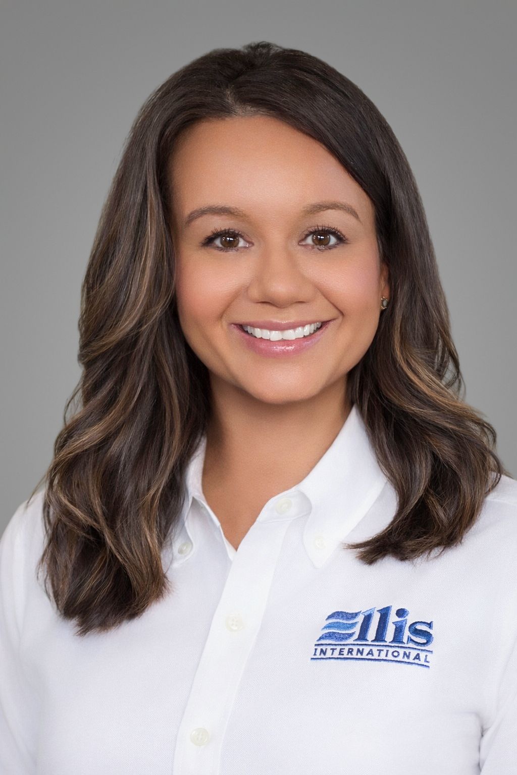 Smiling woman in a white Eliis-branded shirt against a gray background