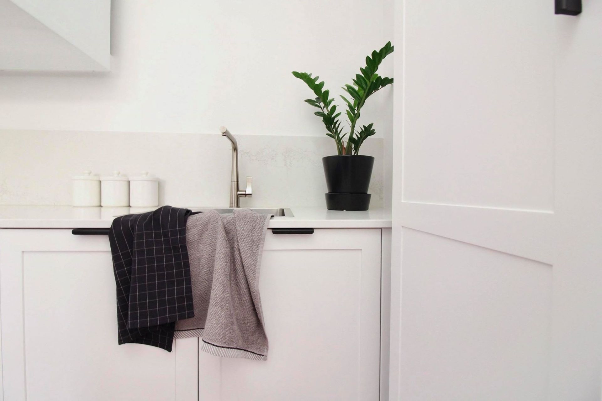 A kitchen with wooden cabinets , stainless steel appliances , a sink , and a large island — Tailored Interiors in Capalaba, QLD
