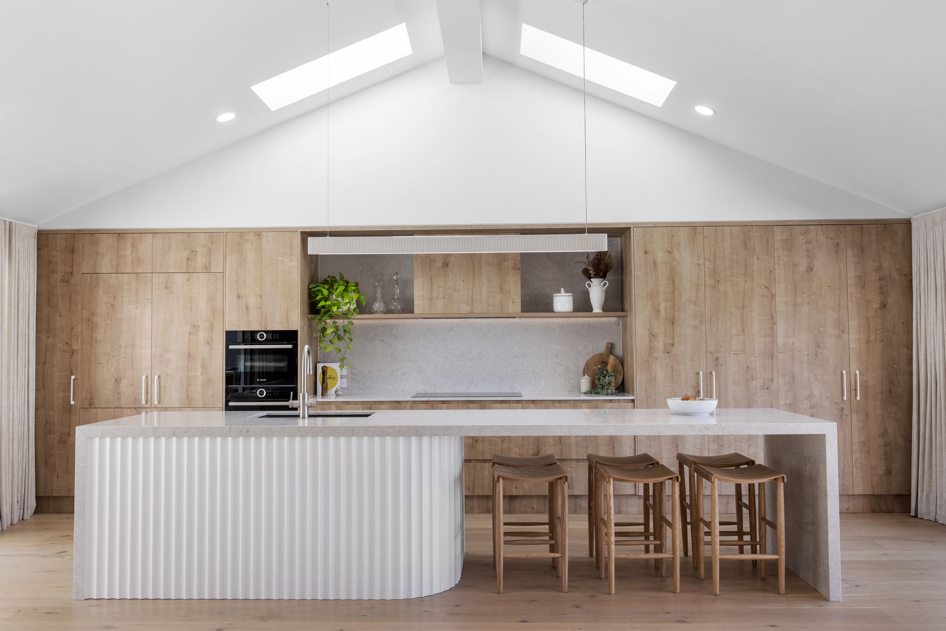 A Kitchen with White Cabinets and Blue Lights on The Ceiling — Tailored Interiors in Coorparoo, QLD