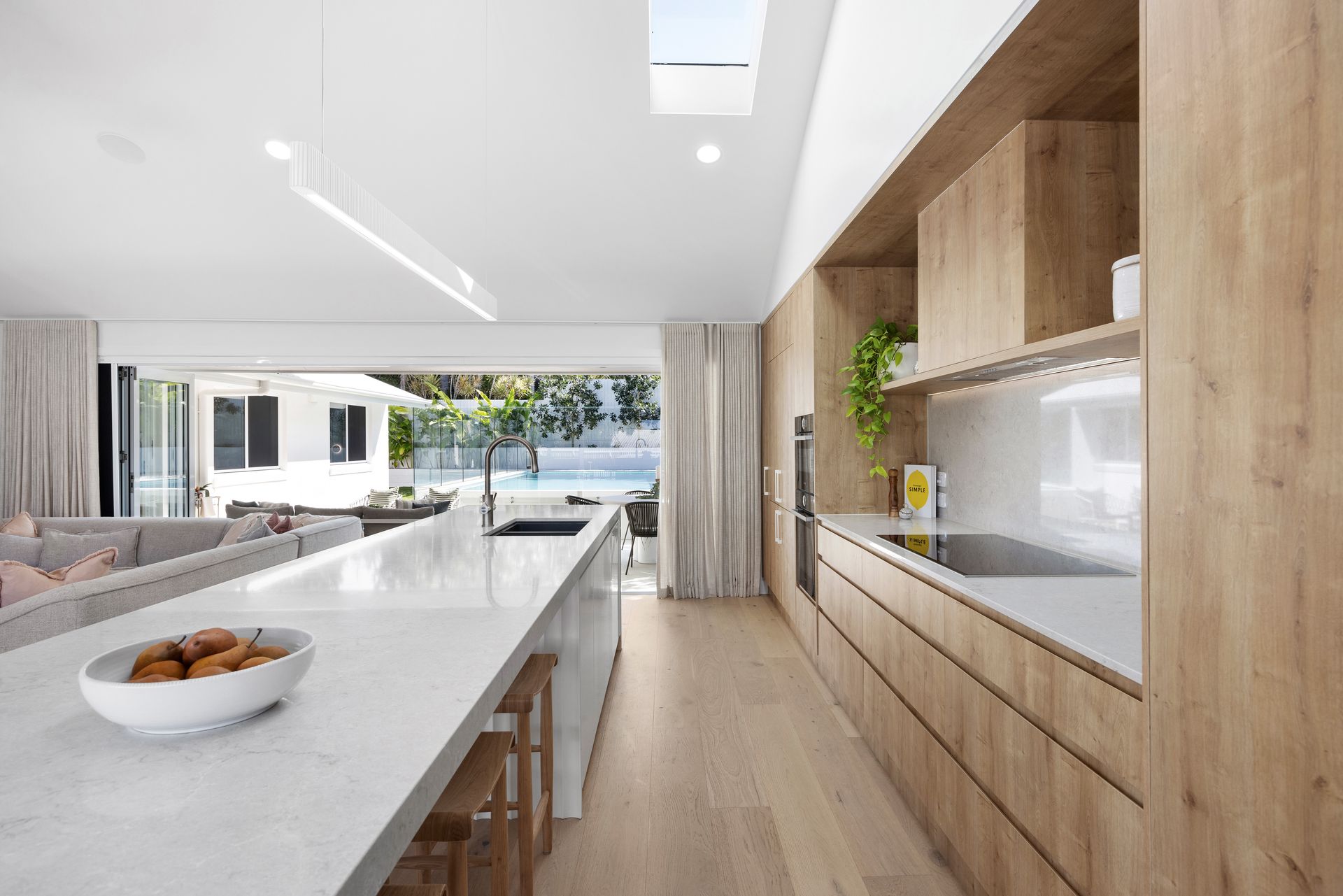 A Kitchen with White Cabinets and A Large Island in The Middle — Tailored Interiors in Wacol, QLD